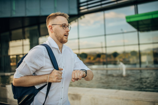 一个年轻英俊的商人上班迟到了图片下载