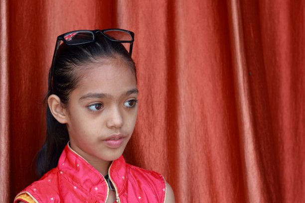 一个印度漂亮的小女孩摆弄着她的眼镜，摆出各种姿势。图片下载