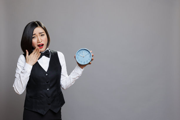服务员打着哈欠，手里拿着闹钟图片下载