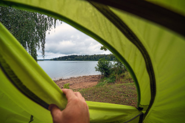 雨停后，一名男子正在打开一顶旅游帐篷图片下载