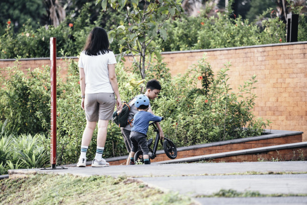亚洲母亲教儿子骑平衡车图片下载