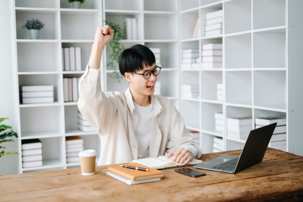 男学生在图书馆记笔记，年轻的亚洲人在大学图书馆坐在书桌前做作业图片下载