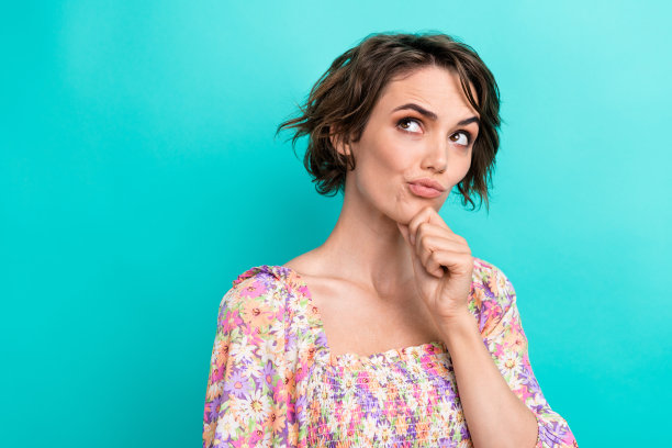 照片的思想沉思的女孩手臂触摸下巴看起来感兴趣的空白空间孤立在蓝绿色的背景图片下载
