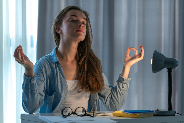 劳累过度的女人感到疲劳，在家里休息和放松，工作到深夜。久坐不动的工作。工人需要休息。工作休息图片下载