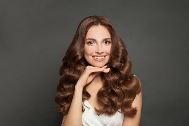 快乐的女人长卷发美丽的头发。图片下载