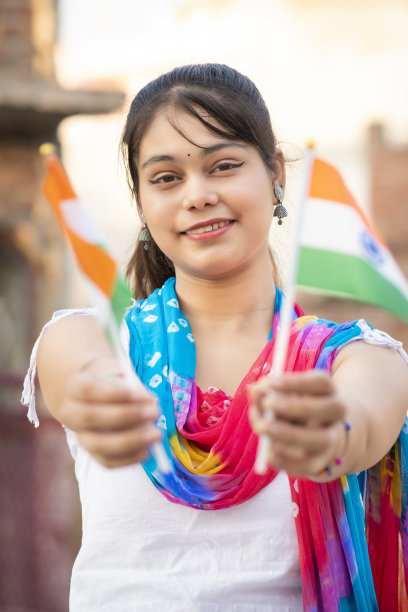 独立日——美丽的印度年轻女子手持两面印度国旗。图片下载