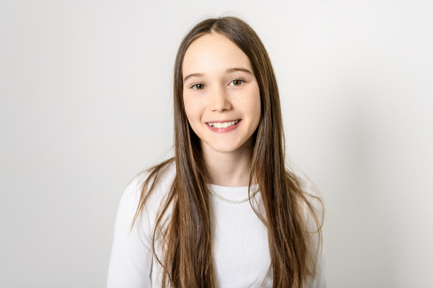 年轻的黑发女孩，十几岁前，穿着白色的摄影棚图片下载