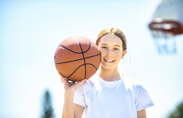 一个小女孩在公园里打篮球的照片图片下载