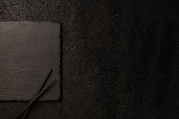 黑色的石板板在黑色的背景与筷子图片下载