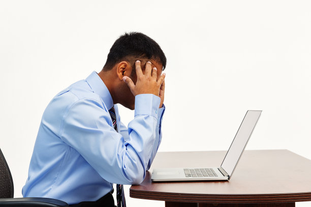 失意的商人在办公桌上用笔记本电脑图片下载