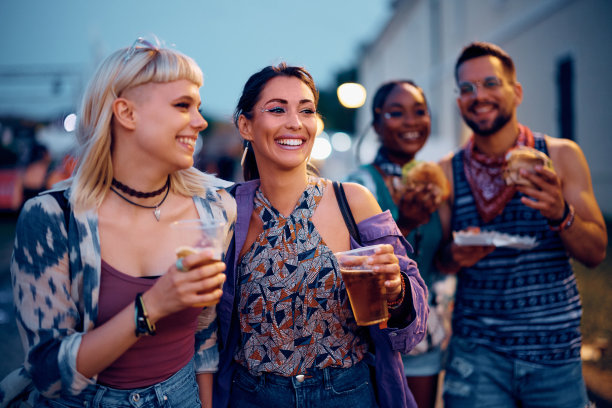 快乐的女人和她的朋友在夏天参加露天音乐会。图片下载