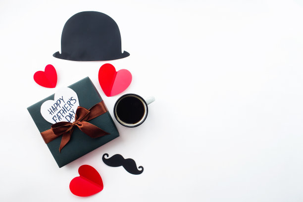 父亲节的节日概念。扁平帽，咖啡杯，礼物，红心和一个有趣的黑色胡子上孤立的白色背景。为铭文复制空间。图片下载