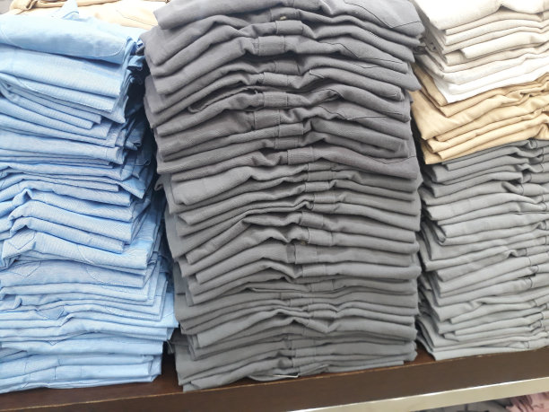 衣架上整齐摆放着五颜六色的折叠布衬衫图片下载