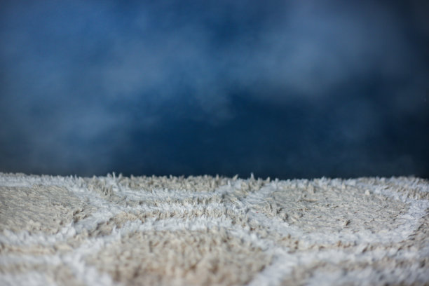 浅色地毯，独立的黑色背景，带有蒸汽。专业清洗图片下载
