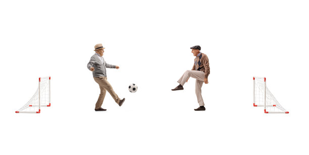 老年人踢着小球门的足球图片下载