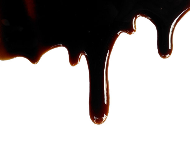 白底酱油。洒出的酱油酱水坑孤立在白色的背景上。洒出的酱油的质地。图片下载