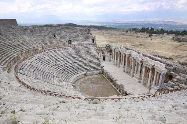 在美丽的粉色天空下，希拉波利斯古城的圆形剧场。联合国教科文组织文化遗产纪念碑。土耳其的棉花堡图片下载