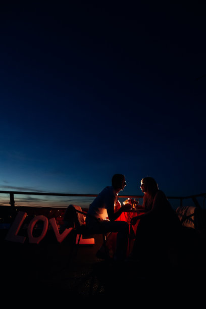 一对恋人坐在喜庆的餐桌旁的剪影图片下载