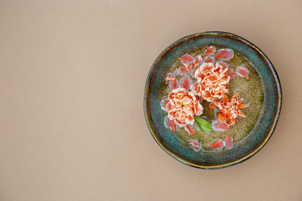 橙色的花在一个质朴的碗装饰背景与复制空间图片下载