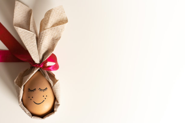 有创意的复活节彩蛋，在明亮的背景上画了一张可爱的脸。复活节快乐的概念。俯视图，模型，模板，复制空间图片下载