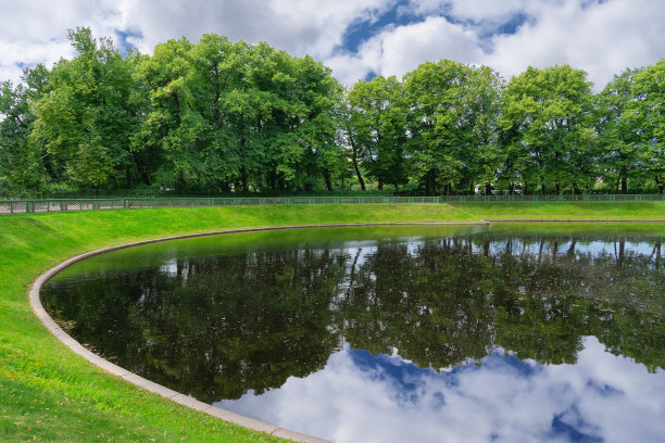 城市公园有一个湖，有一个古老的篱笆和大树，夏天的一天图片下载