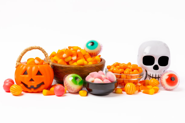 在白色背景上孤立的糖果玉米。万圣节的概念。一桶万圣节南瓜南瓜灯和玉米糖庆祝万圣节。南瓜脸上带着可怕的微笑。糖果桶。图片下载