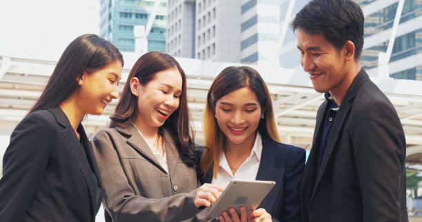 商业伙伴团队在户外开会，聊天，一起玩，用智能平板电脑查看新闻和公司电子邮件。多元化多民族的商务人士坐在外面谈论团队合作图片下载