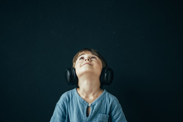 小男孩戴着耳机听音乐图片下载