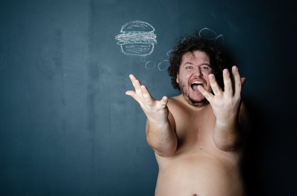 饮食和健康的生活方式。吃汉堡的滑稽胖子。图片下载