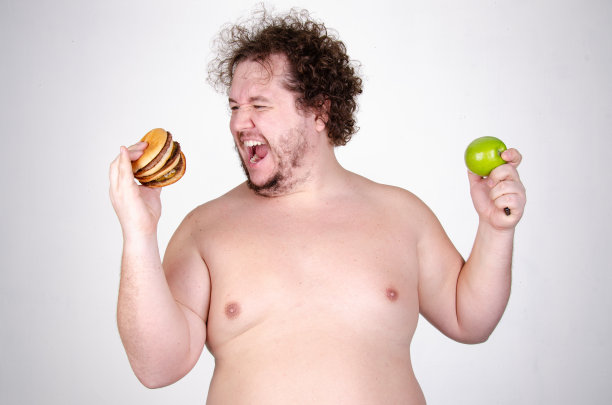 饮食和健康的生活方式。吃汉堡的滑稽胖子。图片下载