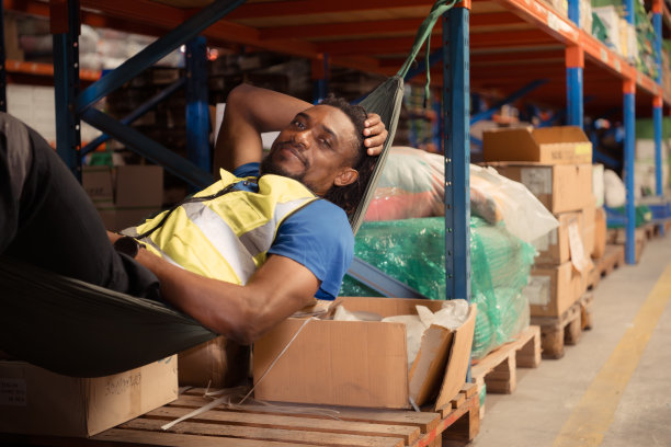 快乐成熟的非裔美国人在仓库的吊床上放松的肖像图片下载