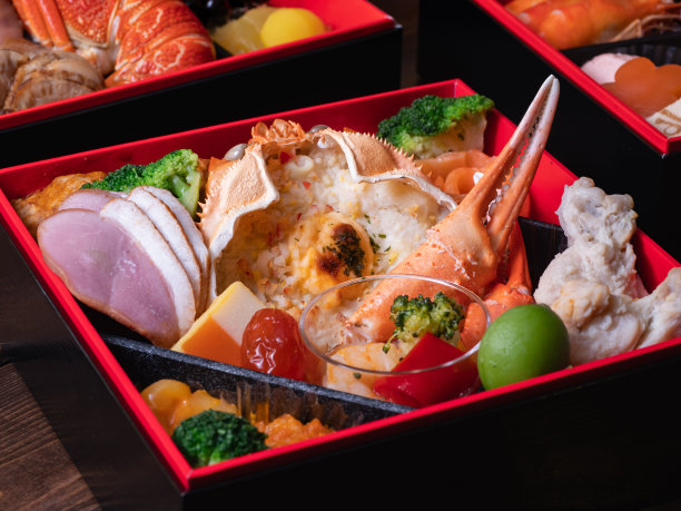 日本新年菜“御食”。传统菜肴，配蟹壳、火腿和蔬菜。图片下载