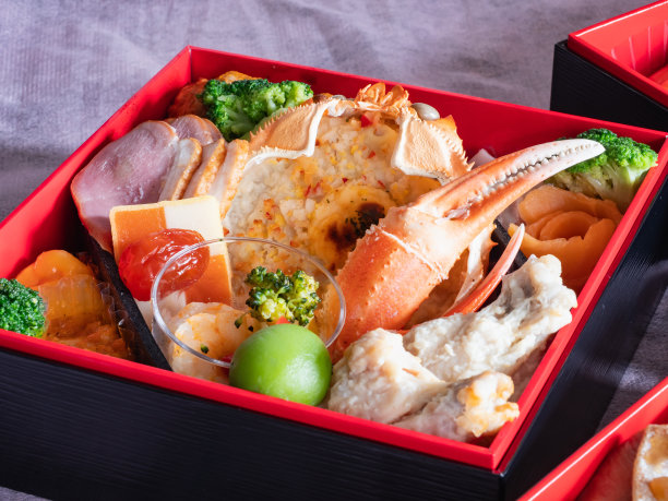 日本新年菜“御食”。传统菜肴，配蟹壳、火腿和蔬菜。图片下载