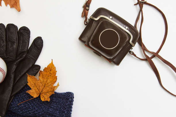 老式胶片相机与皮革手套和针织帽在白色的背景图片下载