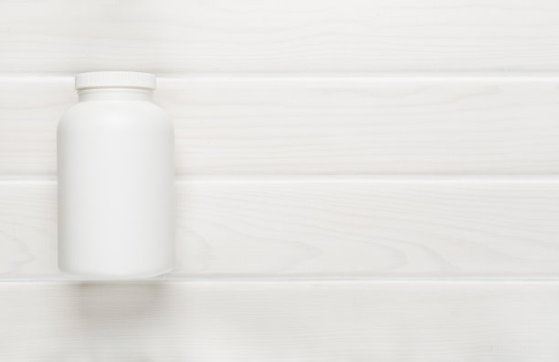 木制背景上的维他命塑料瓶，俯视图图片下载