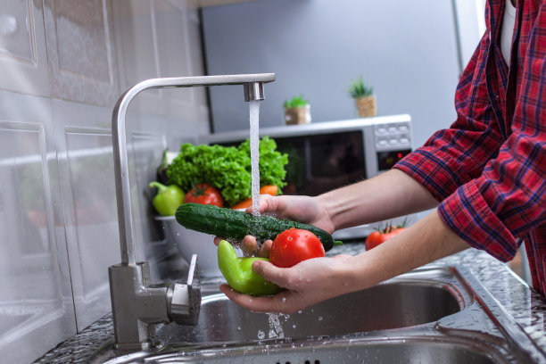 一名妇女正在清洗做沙拉用的蔬菜。正确和健康的食物，适当的营养图片下载