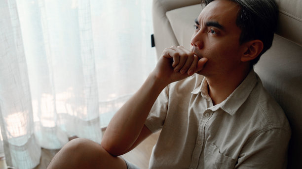 一个悲伤沮丧的亚洲成年男性坐在地板上的特写照片图片下载