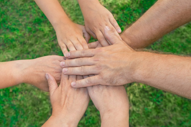 携手成为一个团队。业务团队合作。近距离的一群多种族的朋友一起携手聚会。多样性的人。合作志愿者社区。多元的多民族合作伙伴。俯视图图片下载
