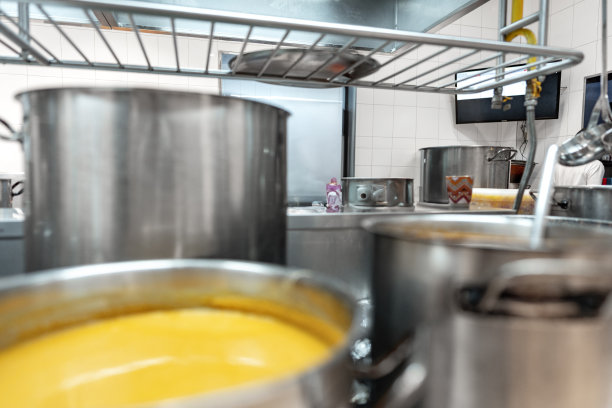 在专业厨房的炉子上用金属锅准备食物图片下载