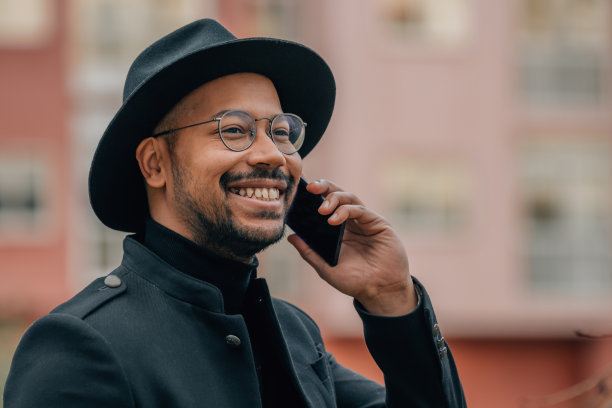 微笑的拉丁男子在街上讲手机图片下载