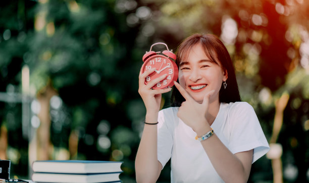 红色闹钟时间管理理念女性用手调整或改变时钟上的时间来工作。图片下载