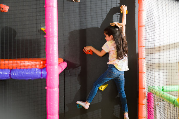 可爱的小女孩在操场上玩攀岩图片下载