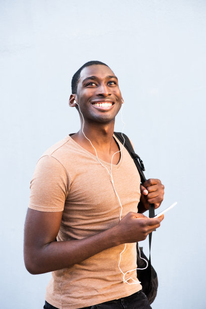 带着手机和耳机的快乐的非裔美国年轻人图片下载