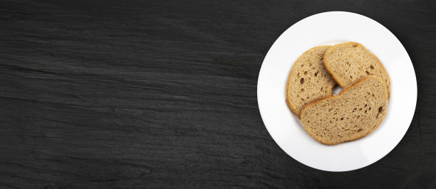 黑盘背景上的黑面包片图片下载