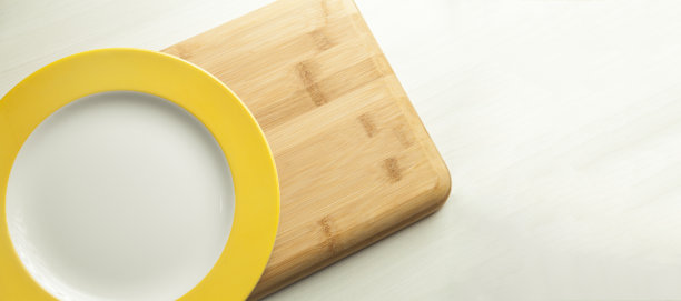 桌上有一盘食物，上面有一块木制的砧板。图片下载