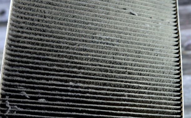 从车辆上拆下的满是灰尘的旧脏二手车空调滤清器，待更换新的，客舱空气碳滤清器，矩形，泡沫橡胶密封条边缘图片下载