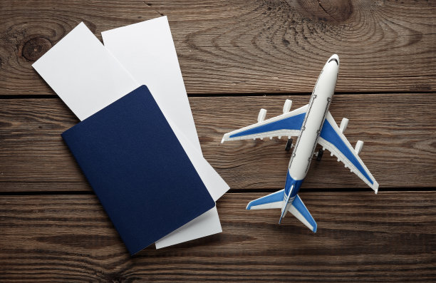 护照与白色空白的机票模型和飞机在木制背景。旅行的概念。设计模板图片下载