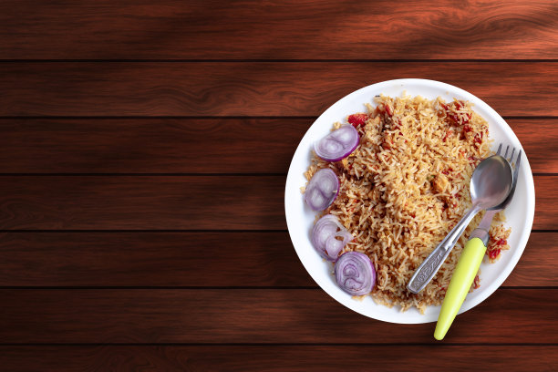 木桌上一盘洋葱鸡肉炒饭的俯视图。本空间图片下载