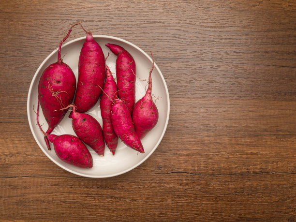 木桌上白色盘子里的日本红薯图片下载