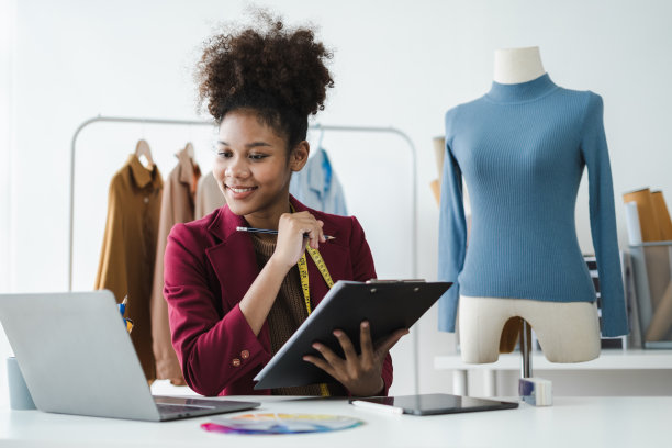 黑人女性，平板电脑和电子商务、时尚或物流领域的小企业，在家远程创业。非裔美国女老板在店里工作时想着衣服的颜色成功了图片下载